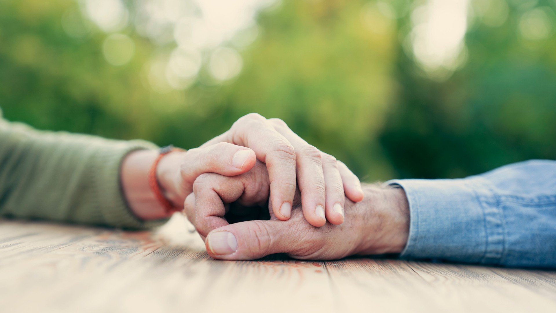 Two people holding hands with compassion and love