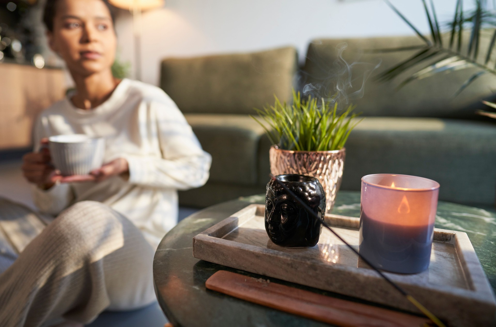 Woman in background at home with incense